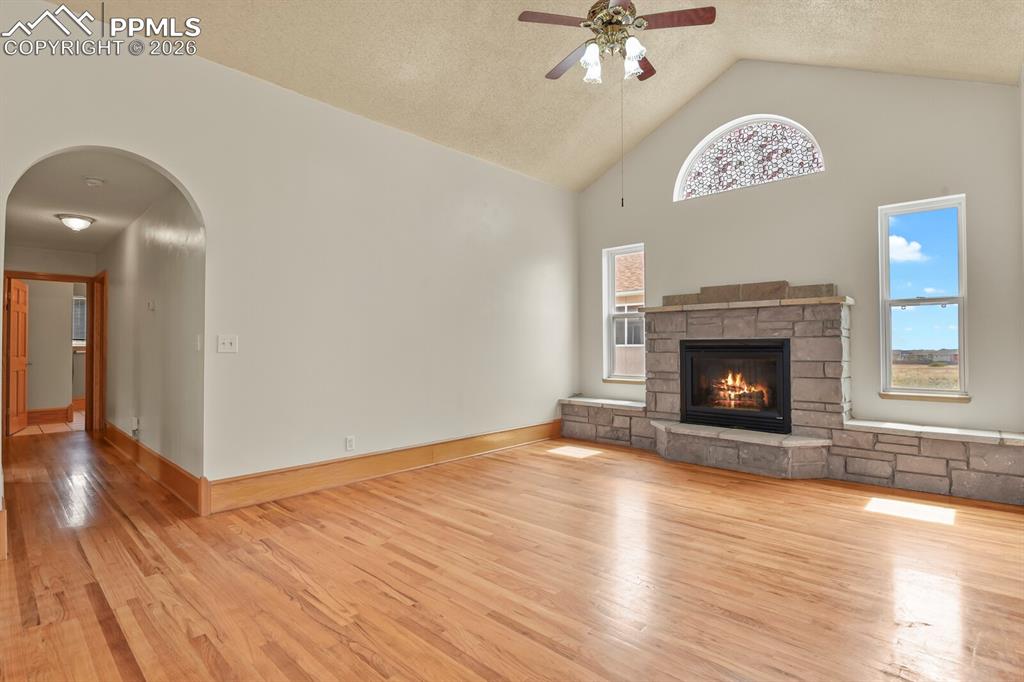 11505 Salinas Road Peyton, CO 80831 - Photo 3 of 37 a view of an empty room with wooden floor a fireplace and a window
