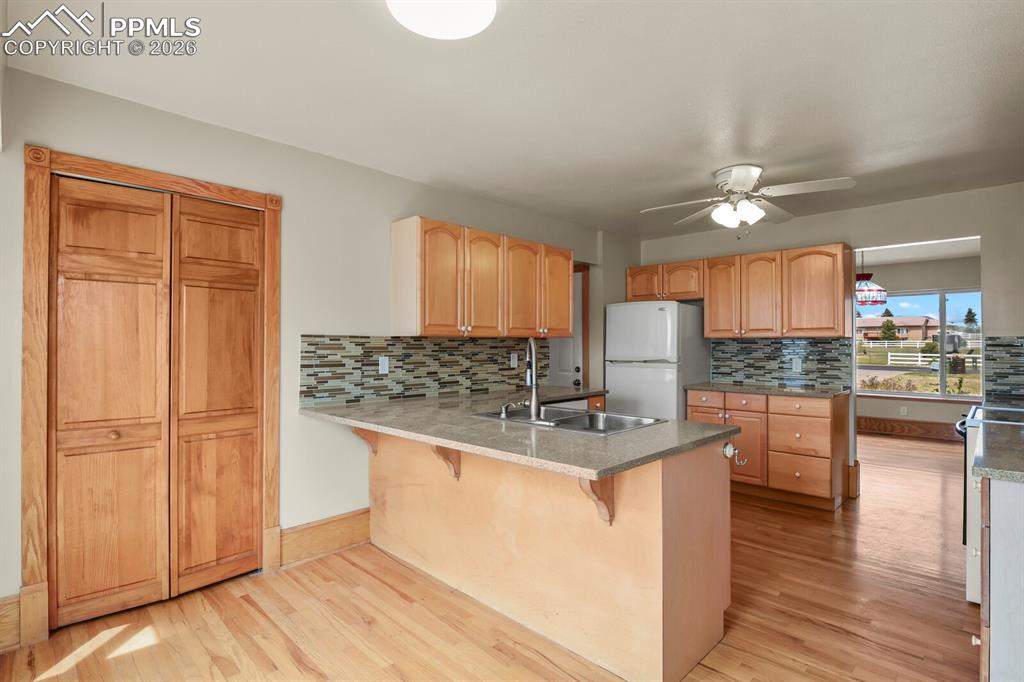 11505 Salinas Road Peyton, CO 80831 - Photo 8 of 37 a kitchen with kitchen island granite countertop a stove cabinets and wooden floor