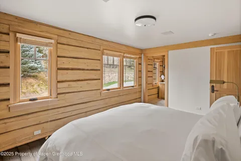 a bedroom with a bed and a large window