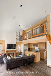 a living room with furniture a flat screen tv and kitchen view