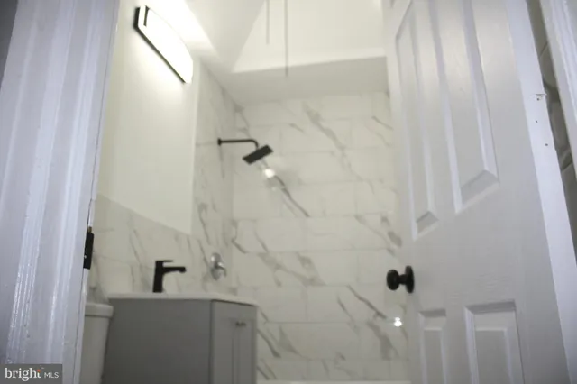 a bathroom with a sink a toilet and shower