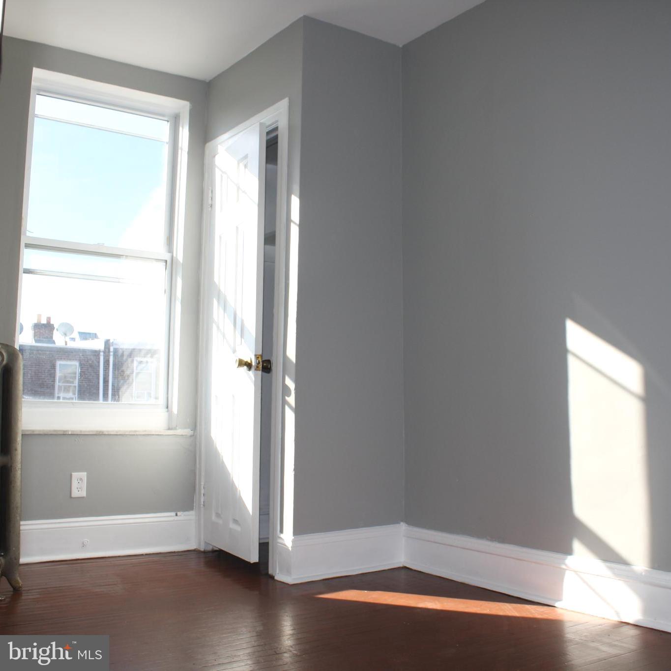 2634 South Daggett Street Philadelphia, PA 19142 - Photo 15 of 28 a view of an empty room with a window and wooden floor