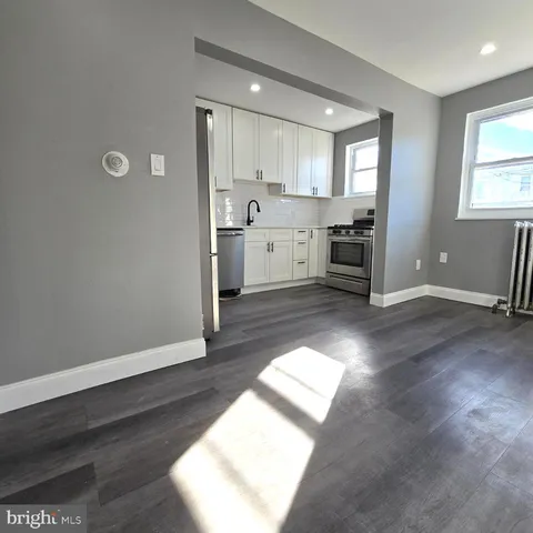 a view of a kitchen with wooden floor and electronic appliances