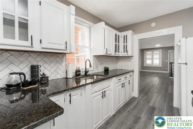 a kitchen with stainless steel appliances granite countertop a stove a sink dishwasher and a microwave oven with wooden cabinets