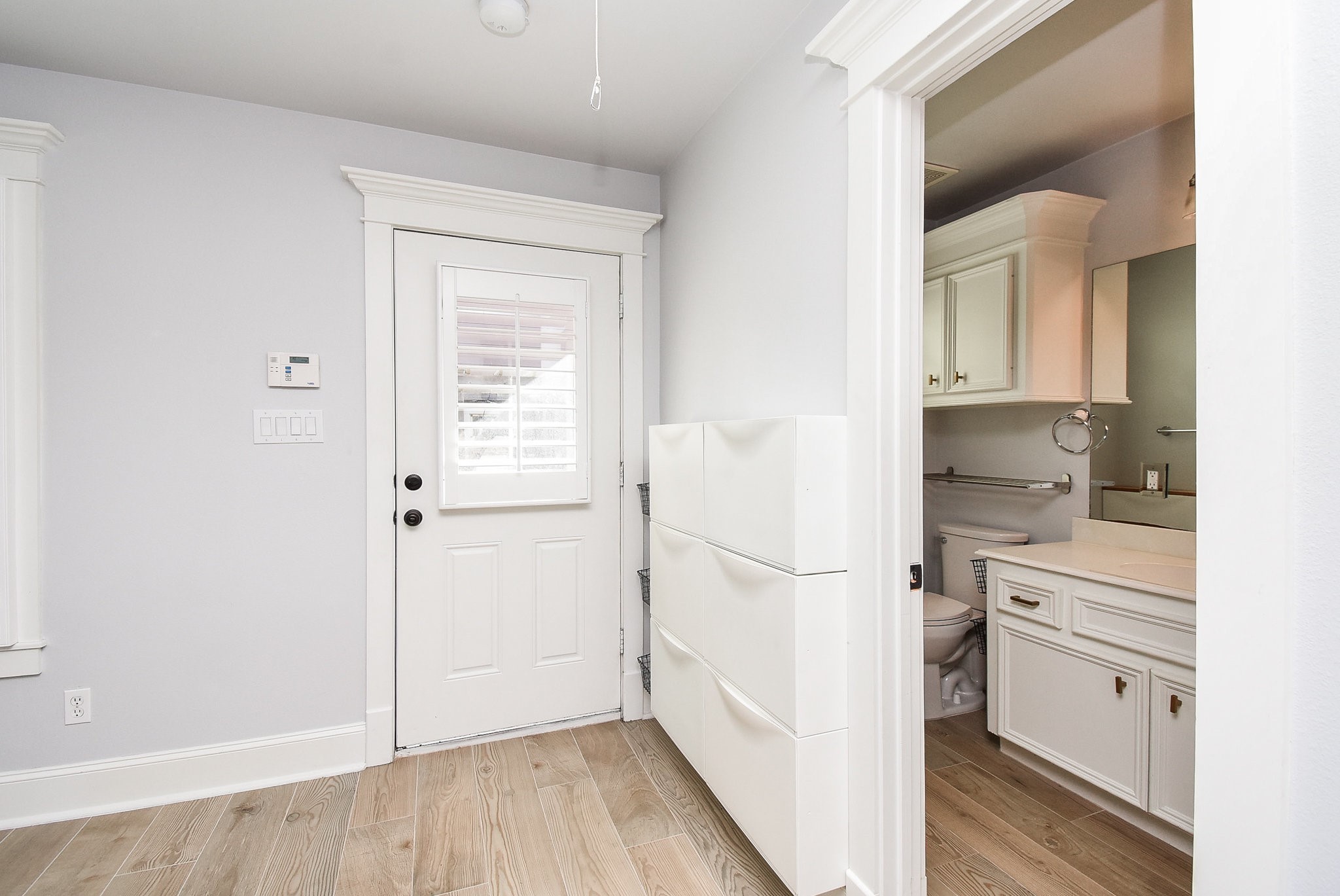 1349 Heights Boulevard, Unit B Houston, TX 77008 - Photo 3 of 32 a hallway with white cabinets and wooden floor