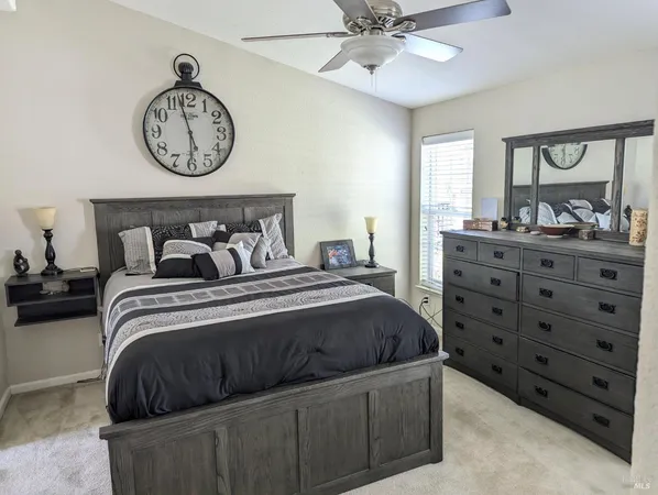 a bedroom with a bed a chandelier and a large mirror on the dresser