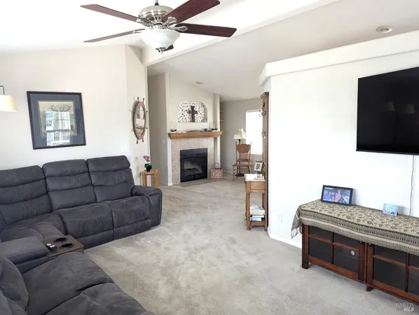a living room with furniture a flat screen tv and a fireplace