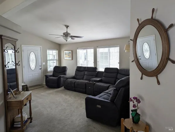 a living room with furniture a mirror and a window