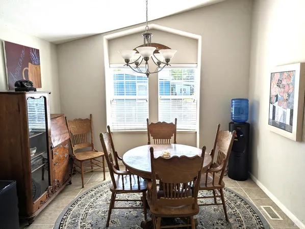 a view of a dining room with furniture a chandelier and wooden floor