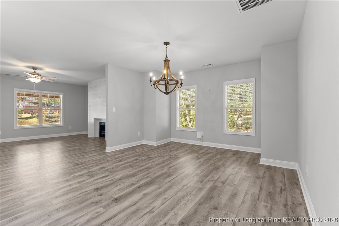 502 North Stewart Street Raeford, NC 28376 - Photo 15 of 48 an empty room with wooden floor chandelier and windows