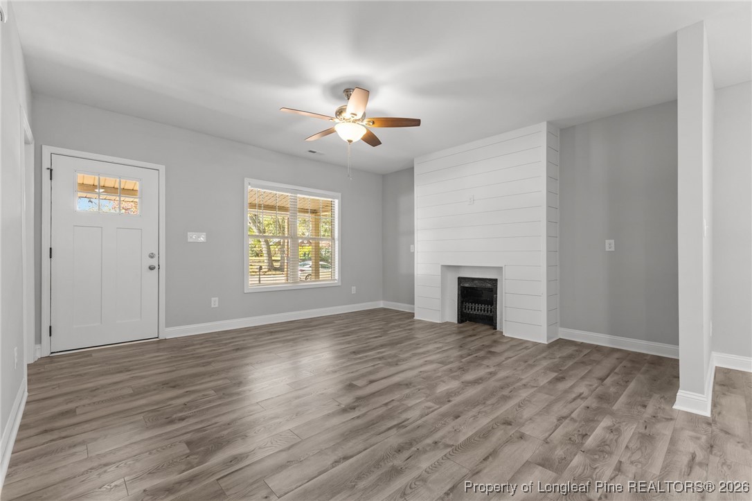502 North Stewart Street Raeford, NC 28376 - Photo 3 of 48 an empty room with windows fireplace and fan