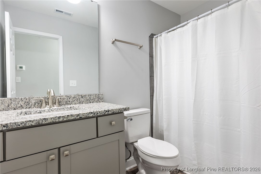 502 North Stewart Street Raeford, NC 28376 - Photo 35 of 48 a bathroom with a granite countertop sink toilet and a mirror