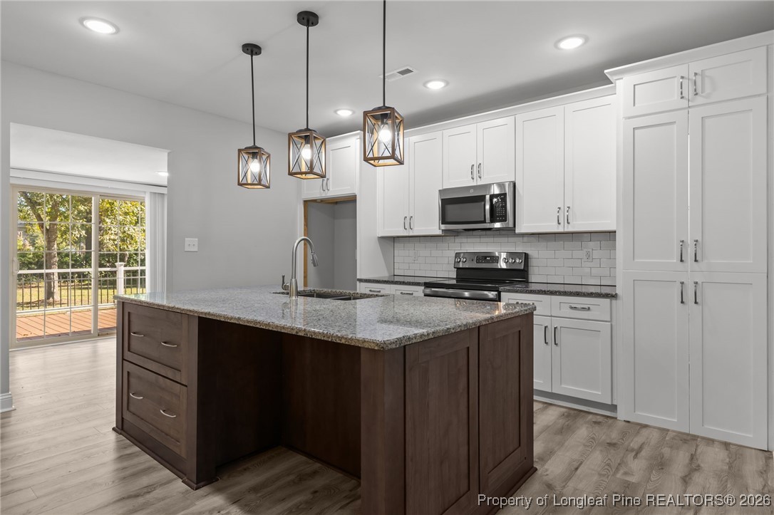502 North Stewart Street Raeford, NC 28376 - Photo 7 of 48 a kitchen with stainless steel appliances granite countertop a stove a sink and a refrigerator