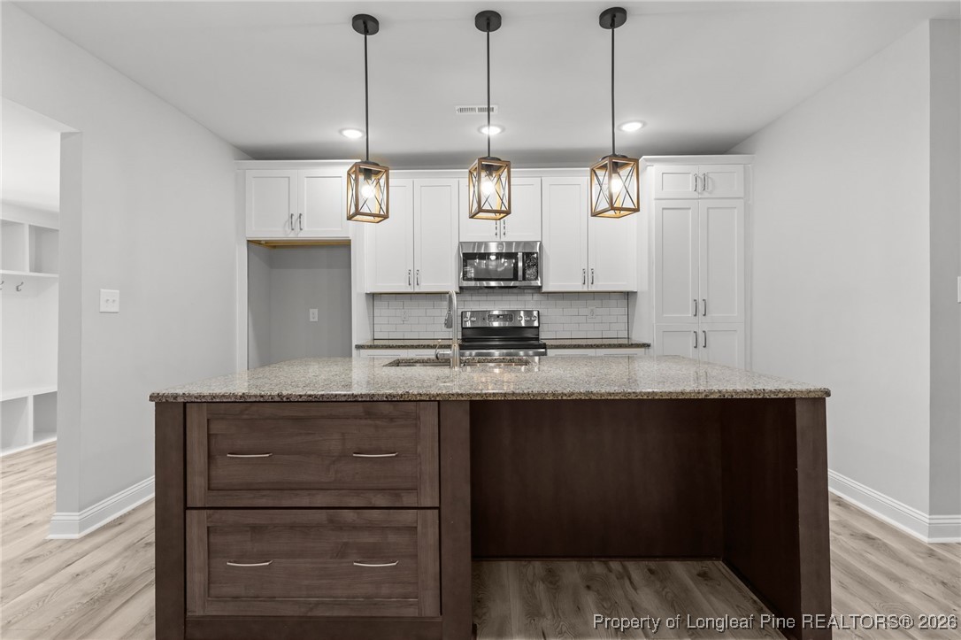 502 North Stewart Street Raeford, NC 28376 - Photo 8 of 48 a kitchen with a sink and chandelier