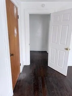 an empty room with wooden floor and window