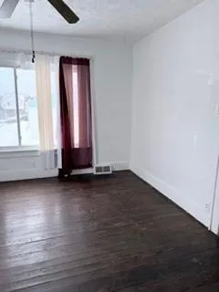 a view of a room with wooden floor and window