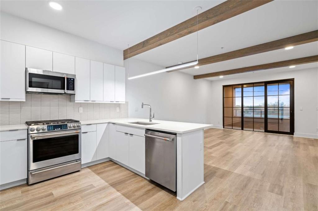 a kitchen with stainless steel appliances granite countertop a stove and a microwave