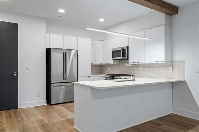 a kitchen with cabinets stainless steel appliances and a counter space