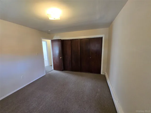 an empty room with closet and windows