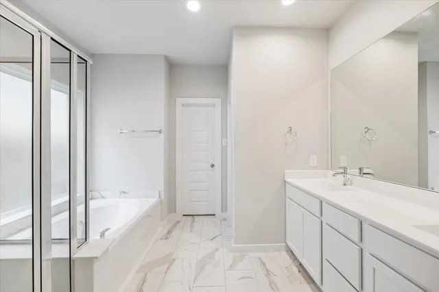a spacious bathroom with a bathtub and a sink