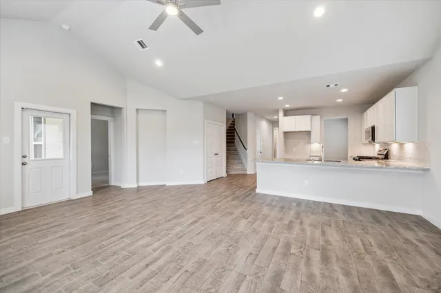 a view of large kitchen with a sink and dishwasher a refrigerator with wooden floor