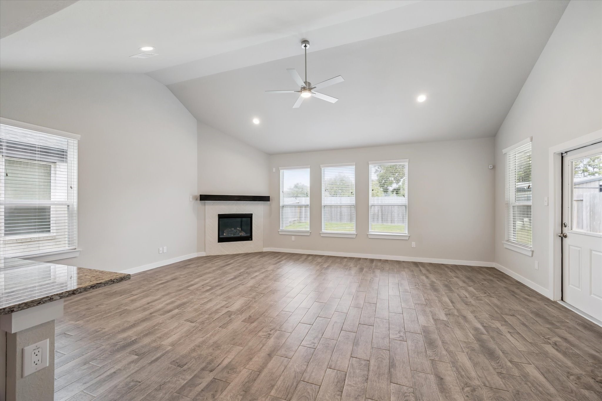 2138 Reed Cave Lane Spring, TX 77386 - Photo 9 of 23 an empty room with wooden floor fireplace and windows