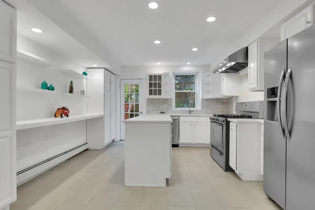 a kitchen with white cabinets and refrigerator