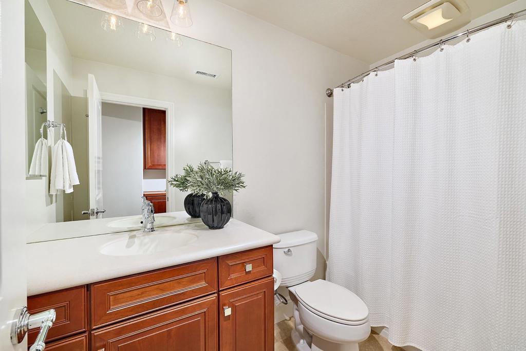 3230 Corte Aliso Carlsbad, CA 92009 - Photo 16 of 23 a bathroom with a sink a toilet and shower curtain