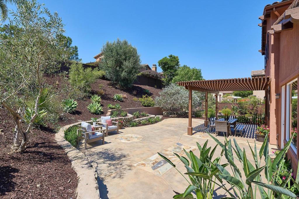 3230 Corte Aliso Carlsbad, CA 92009 - Photo 23 of 23 a view of a patio with table and chairs potted plants with wooden fence