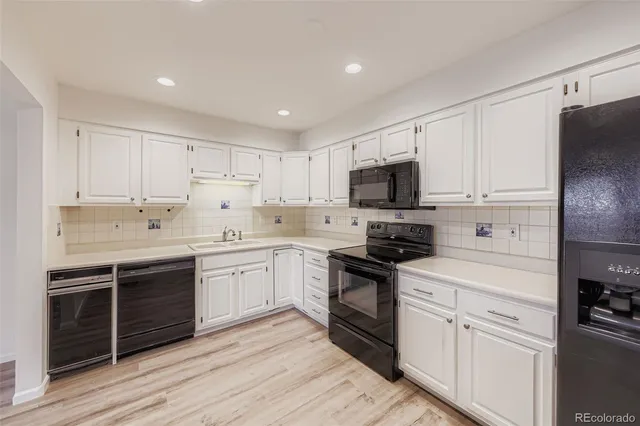 a kitchen with granite countertop a sink stainless steel appliances and cabinets
