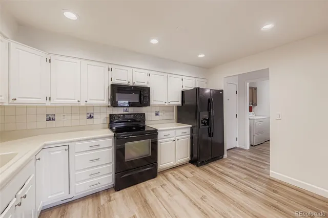 a kitchen with a refrigerator stove and white cabinets