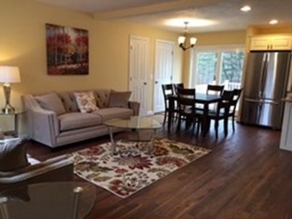 211 Barre Paxton Road, Unit 12 Rutland, MA 01543 - Photo 8 of 10 a living room with furniture a refrigerator and kitchen view