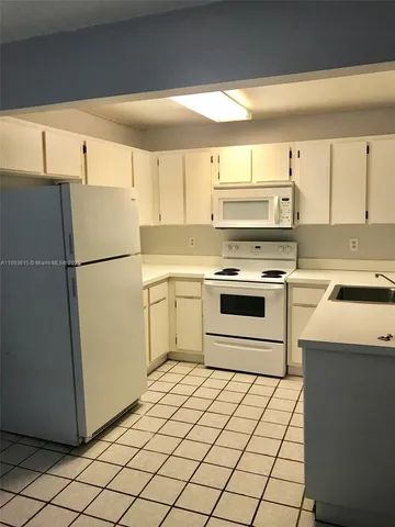 a kitchen with a stove top oven sink and a refrigerator