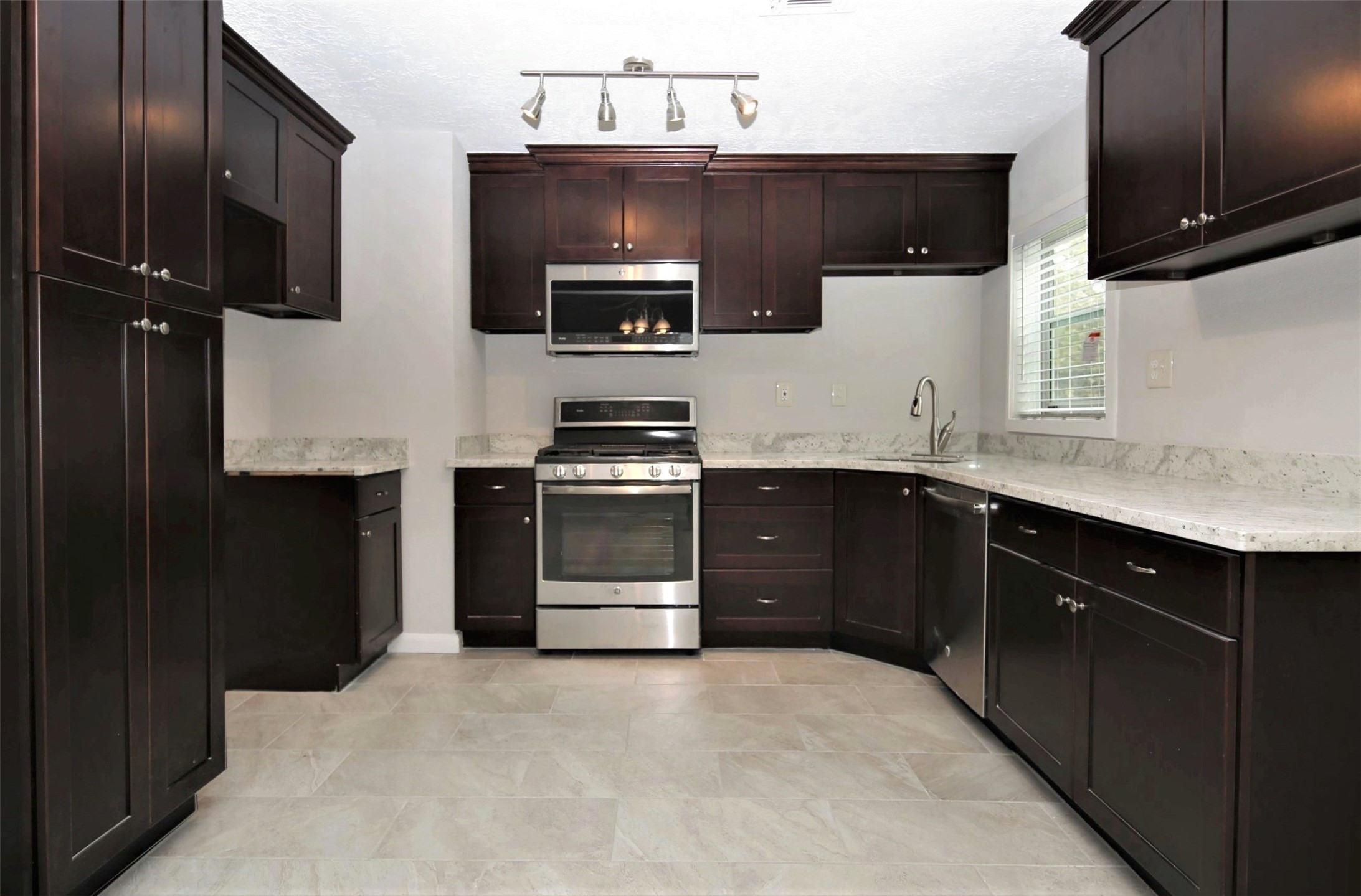 4830 Culmore Drive Houston, TX 77021 - Photo 4 of 13 a kitchen with stainless steel appliances a stove sink microwave and refrigerator
