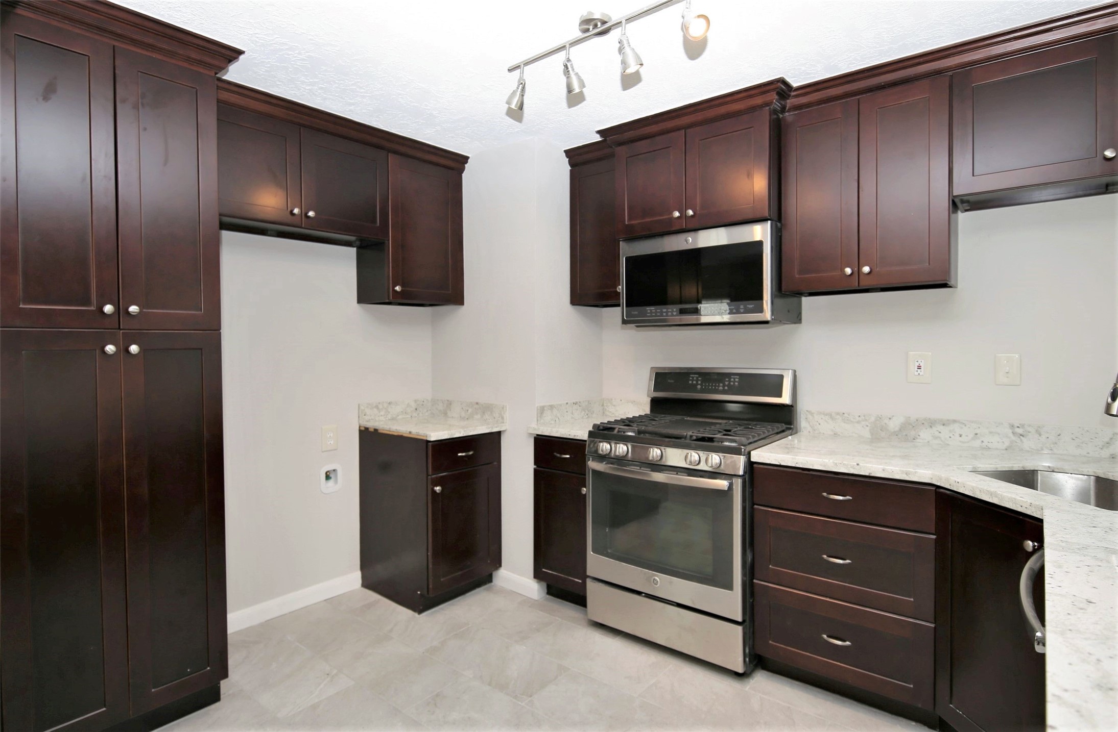 4830 Culmore Drive Houston, TX 77021 - Photo 6 of 13 a kitchen with stainless steel appliances granite countertop a stove a microwave and cabinets