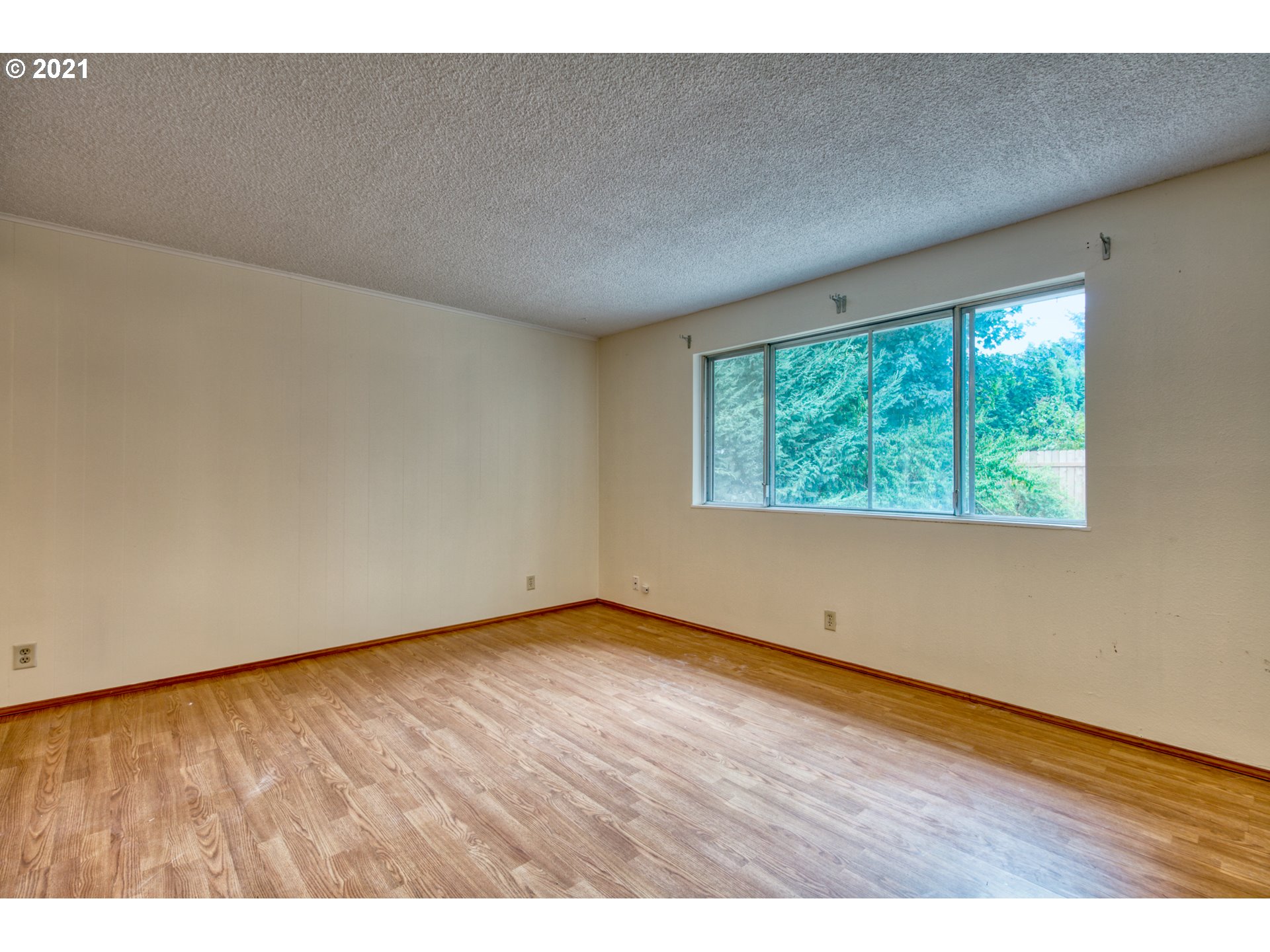 6509 E Street Springfield, OR 97478 - Photo 8 of 28 an empty room with wooden floor and windows
