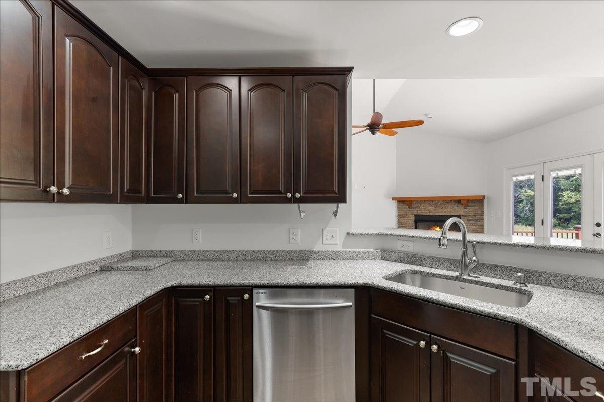 11208 Range Road Rougemont, NC 27572 - Photo 11 of 40 a kitchen with granite countertop a sink and a wooden cabinets