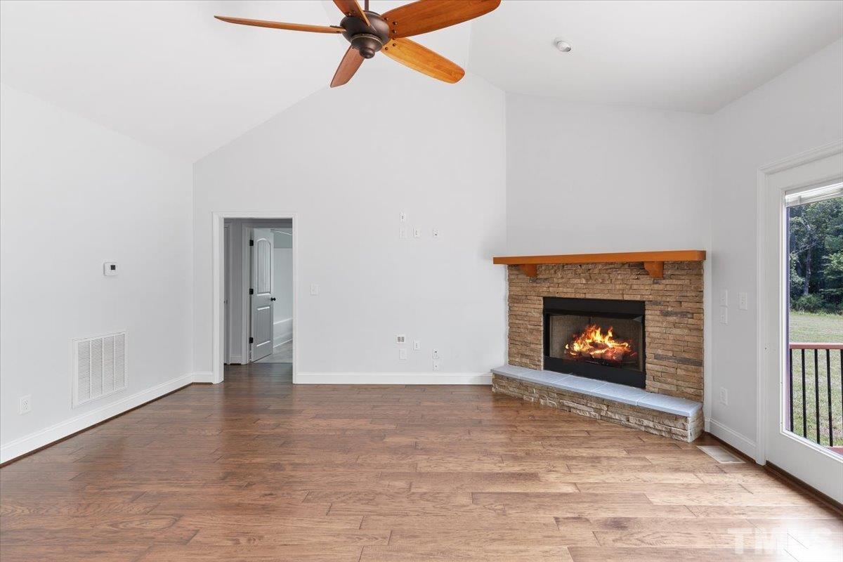 11208 Range Road Rougemont, NC 27572 - Photo 7 of 40 a view of an empty room with chandelier fan and fire place