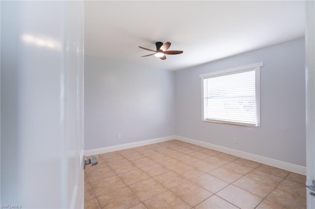 1940 48th Street Southwest Naples, FL 34116 - Photo 23 of 33 Neutral-toned room featuring ceramic tile flooring, a window with horizontal blinds, and a ceiling fan with integrated lighting