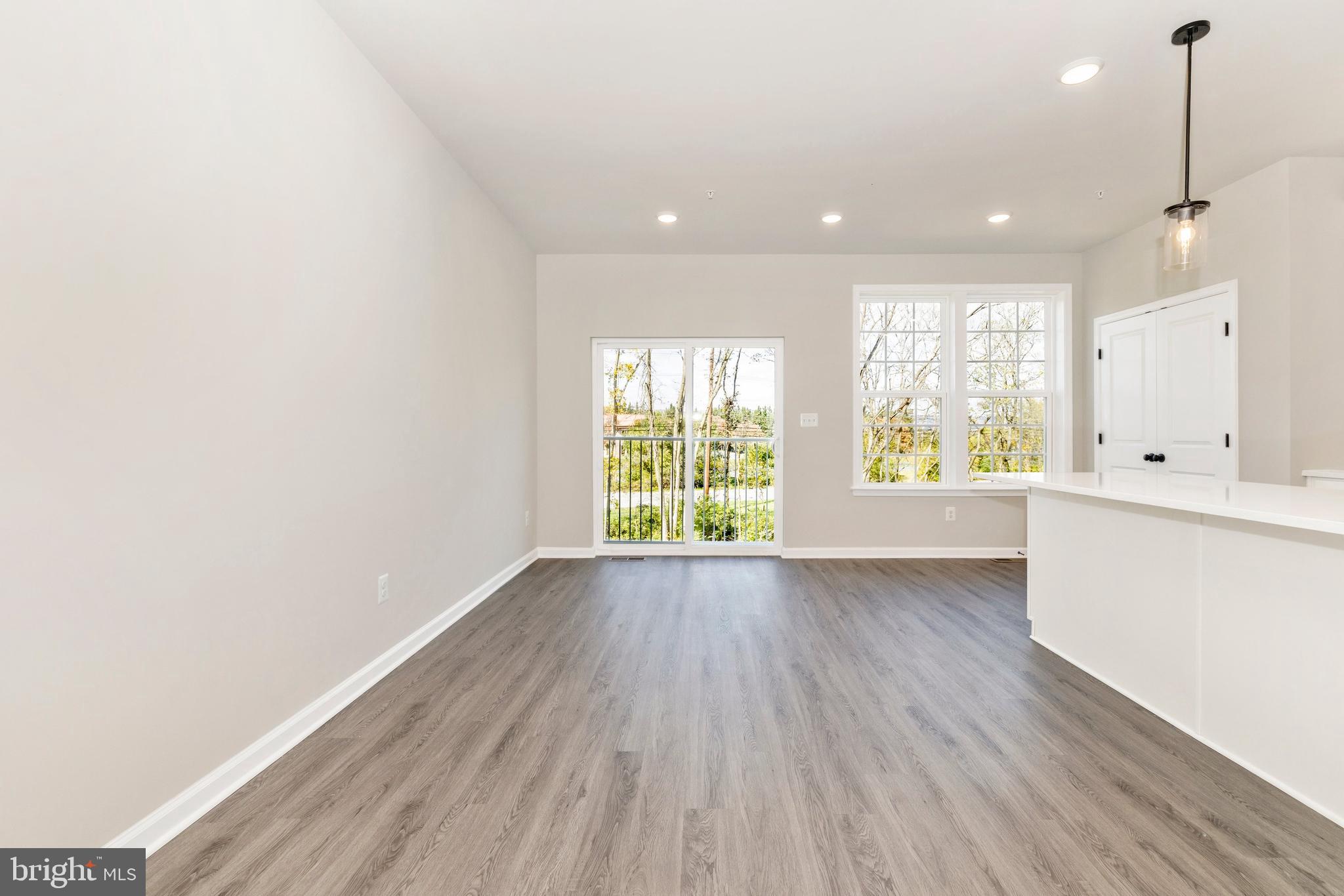 101 Spring Bank Way Frederick, MD 21701 - Photo 13 of 20 a view of an empty room with wooden floor and a window