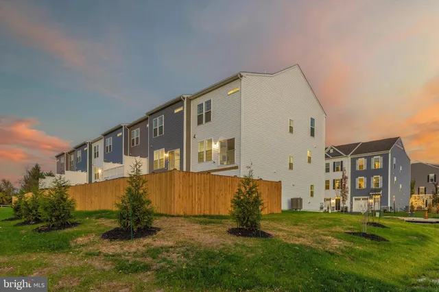 a view of a big house with a big yard and large trees