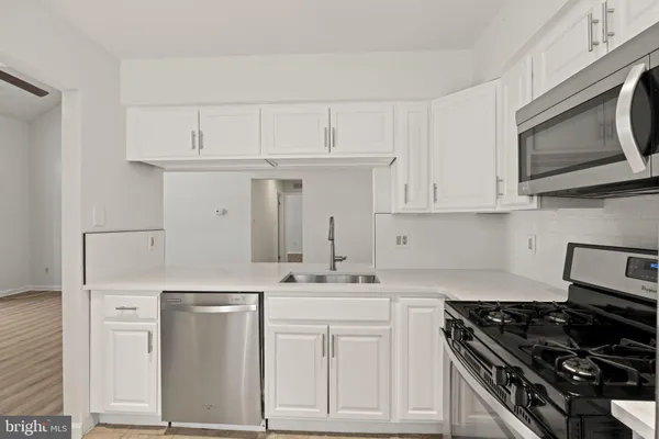 a kitchen with white cabinets and appliances