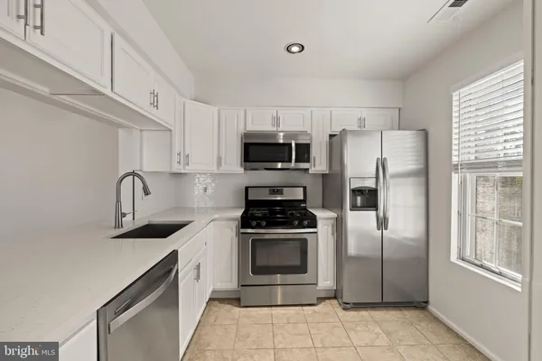 a kitchen with stainless steel appliances a refrigerator sink and cabinets