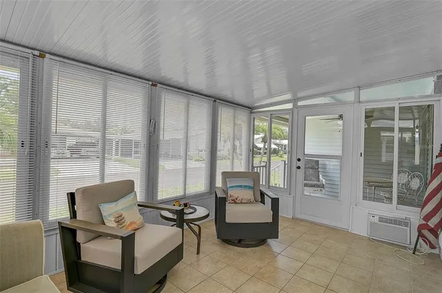 a living room with furniture and floor to ceiling windows
