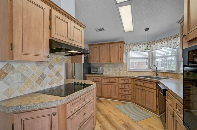 a kitchen with stainless steel appliances granite countertop a sink stove and cabinets