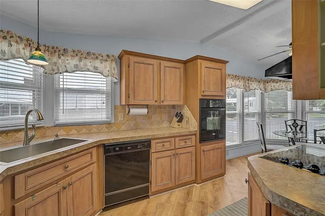 a kitchen with granite countertop a sink and cabinets