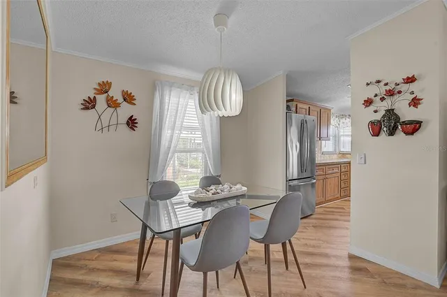 a dining room with furniture a chandelier and wooden floor