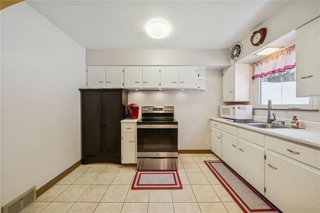 811 5th Street Trafford, PA 15085 - Photo 11 of 36 a kitchen with cabinets a stove and a refrigerator