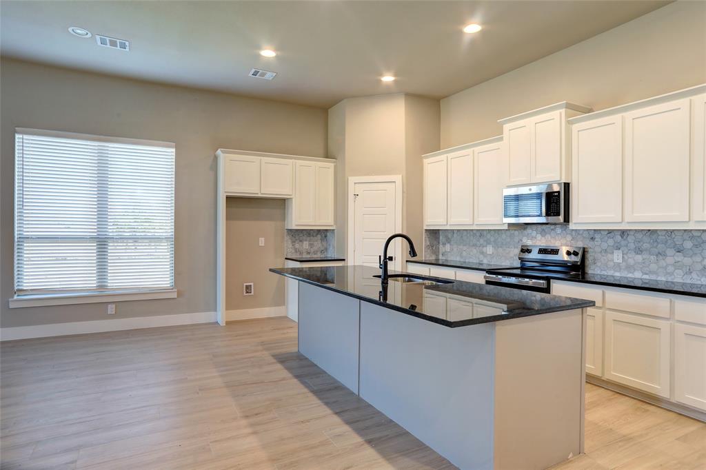202 Pennington Road Josephine, TX 75173 - Photo 5 of 23 a kitchen with stainless steel appliances granite countertop a sink stove and cabinets