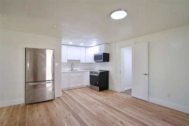 a kitchen with a refrigerator and a stove top oven